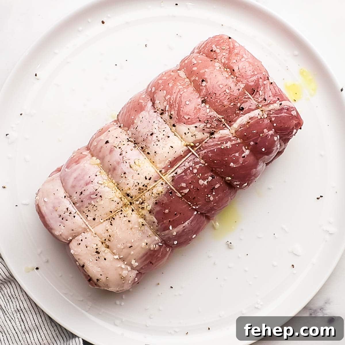 pork loin tied with strings and sprinkled with salt, pepper, and olive oil