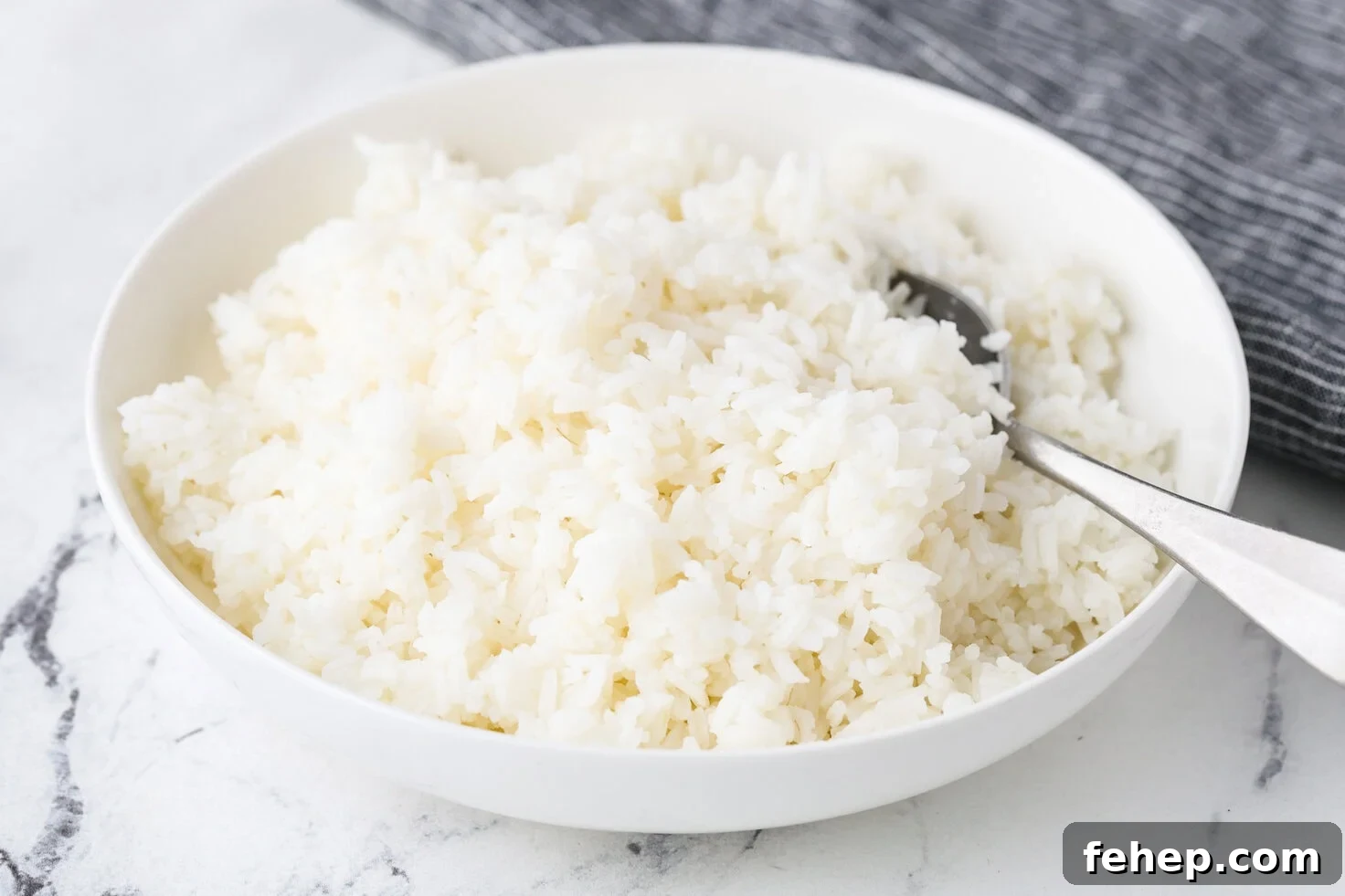 A close up image of cooked jasmine rice in a serving bowl.