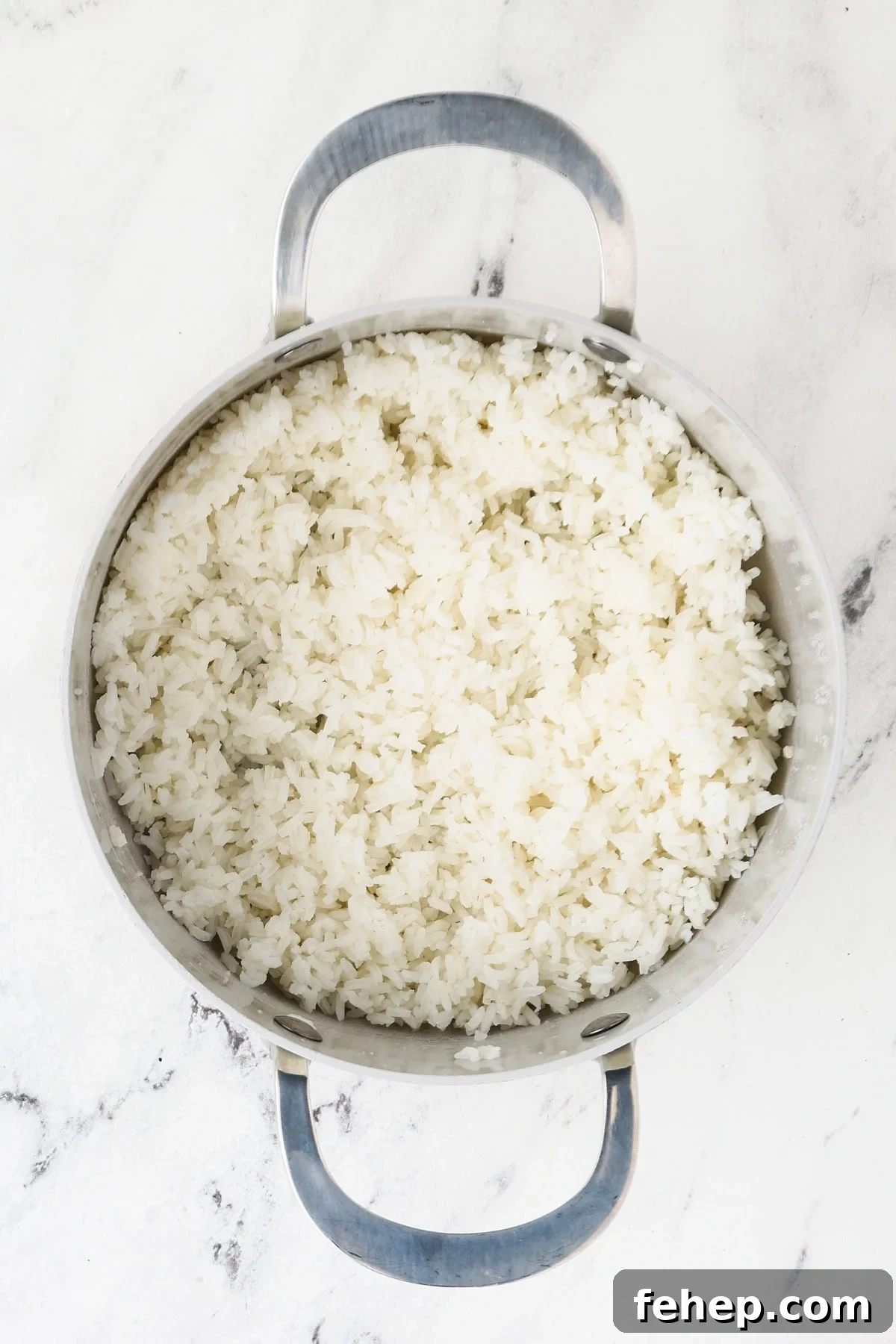 An overhead image of the cooked jasmine rice in a saucepan.