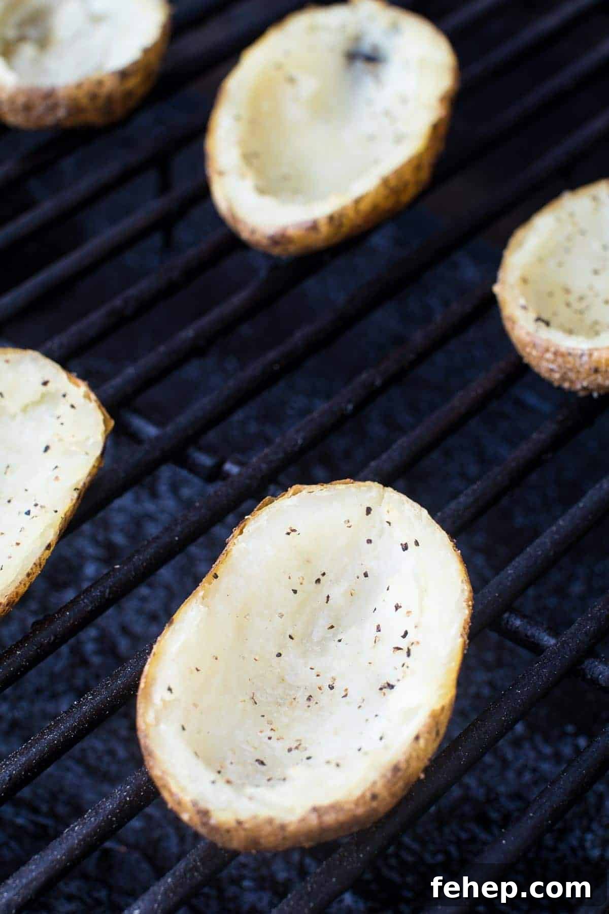 Empty potato skins seasoned with pepper and salt on smoker