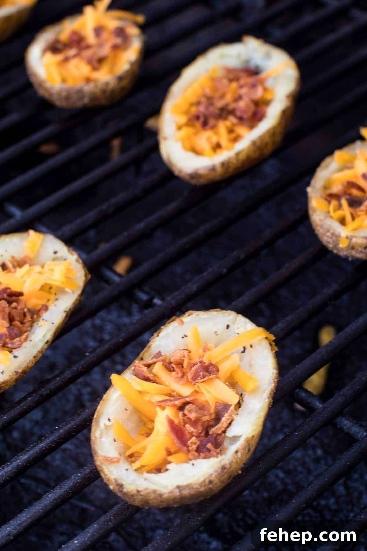 Potato Skins on Smoker filled with bacon bits and shredded cheese.
