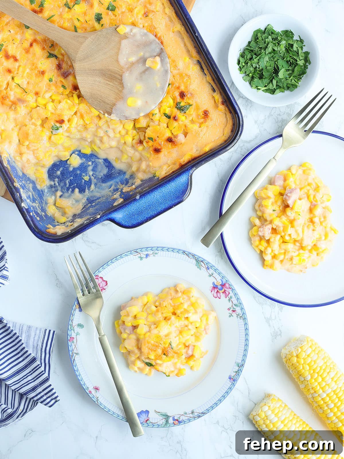 Serving of cheesy corn casserole on a plate with a fork.