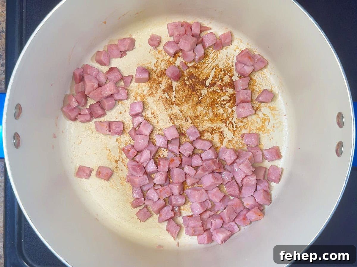 Diced ham browning in a large pot.