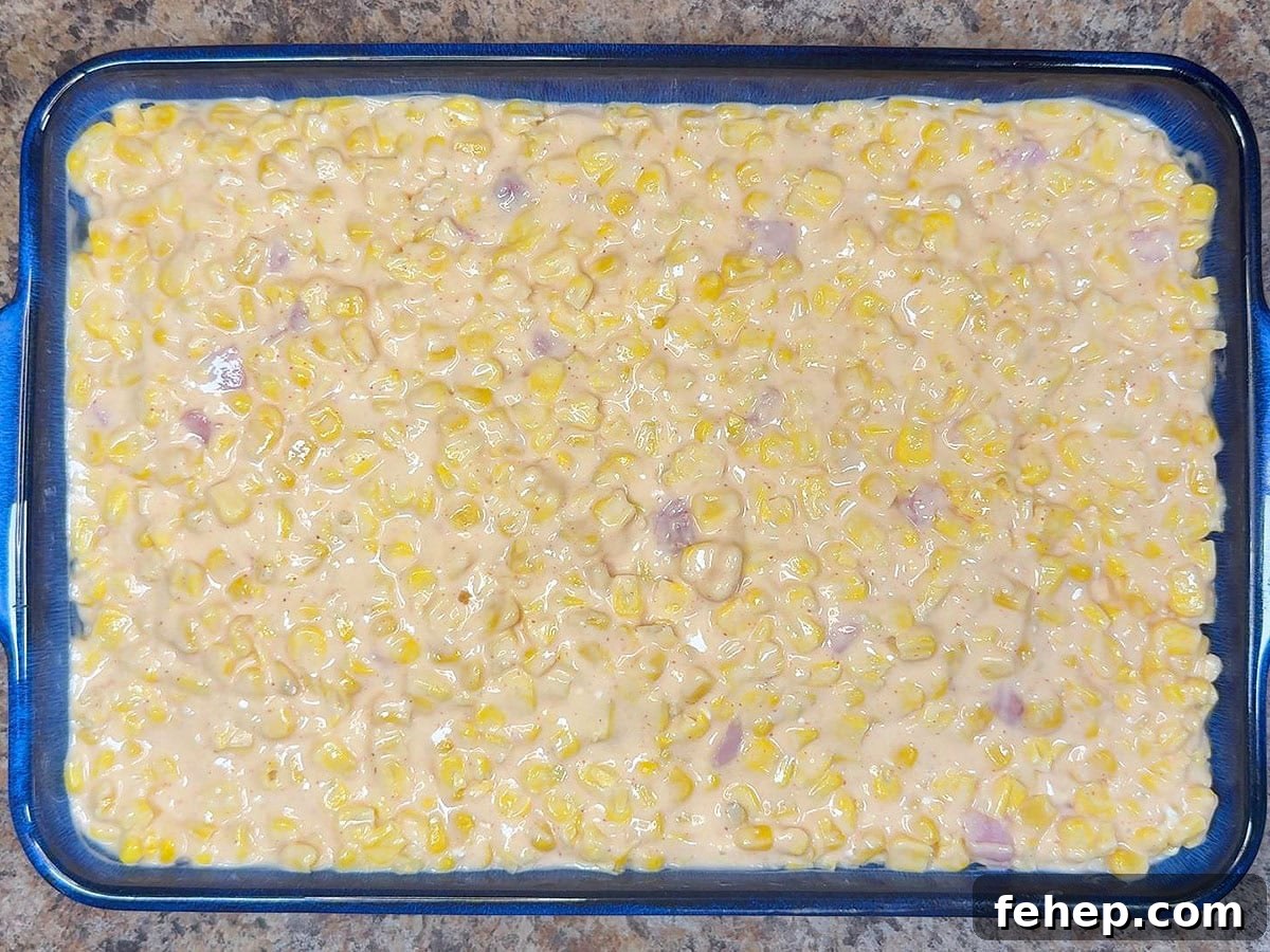 Cheesy corn casserole spread into the bottom of a greased casserole dish.
