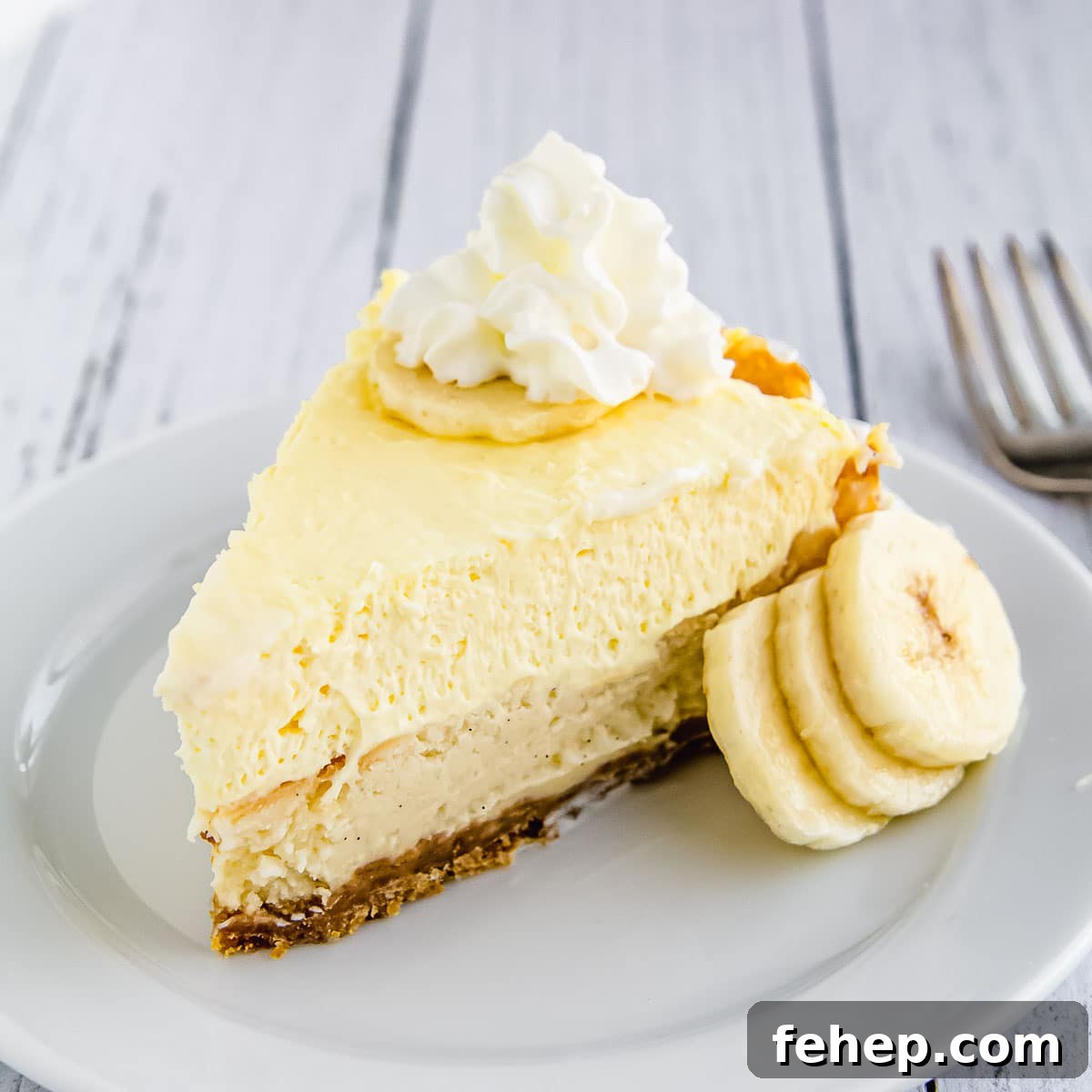 A slice of banana cream cheesecake on a plate.